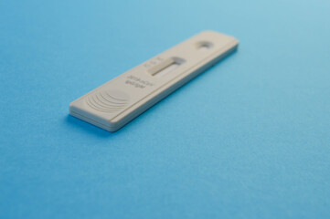 individual set for self-diagnosis of coronavirus. test strip on a blue matte background. window for a drop of blood, test for self-blood analysis