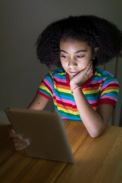 ten year-old bi-racial girl looking at ipad at table