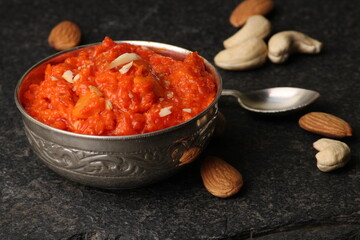 Gajar halwa is a carrot-based sweet dessert pudding from India. Garnished with Cashew almond nuts and Served in silver bowl
