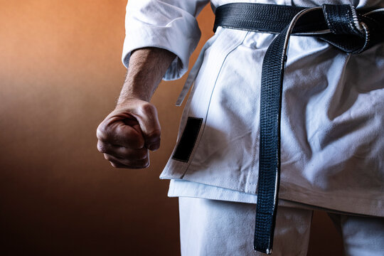 Unrecognizable karateka with black belt in firm position