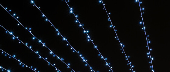 Bright festive lines of cold flickering lights on a black background