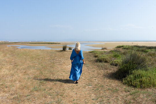 hippie woman in a blue dress on the beach