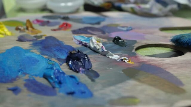 mixed oil paints on the palette. creative workplace of the artist.