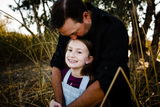 Dad Kissing Daughter on Top of Head at Park in Chula Vista