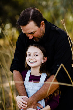 Dad Kissing Daughter on Top of Head at Park in Chula Vista