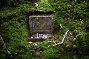 Coins in stone shrine at Japanese zen temple garden