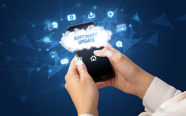 Female hand holding smartphone with SOFTWARE UPDATE inscription, cloud technology concept