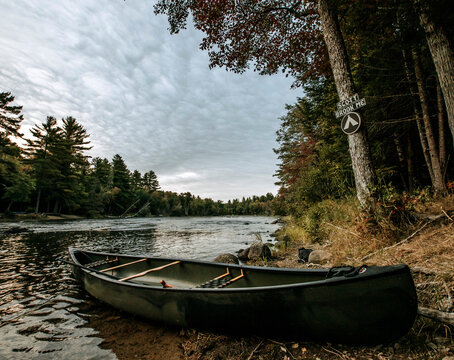 Camouflage canoe sits on bank of campsite Saint Croix River, Maine
