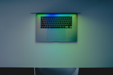 Laptop computer standing on a table, low key blue light image sh