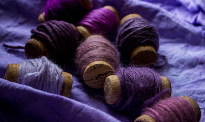 Purple shades of thread are wrapped on wine corks. Violet background. High quality photo
