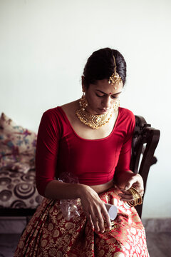 Indian bride prepares for traditional indian wedding with red sari