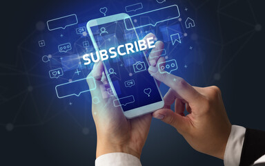 Female hand typing on smartphone with SUBSCRIBE inscription, social media concept