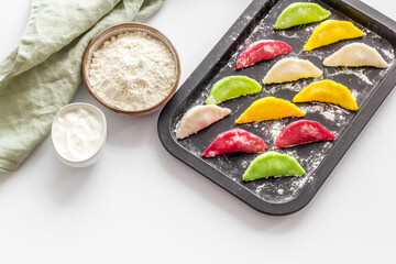 Top view of colorful raw dumplings on baking sheet