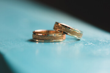 two wedding rings on blue surface