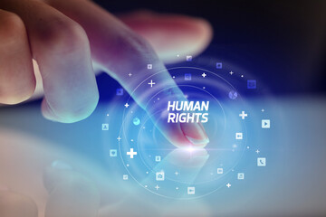 Finger touching tablet with social media icons and HUMAN RIGHTS