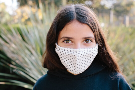 Portrait Of A Tween Girl Wearing A Cloth Face Mask With A Star Pattern