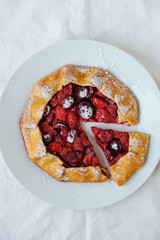 Delicious freshly baked vegan strawberry and cherry galette on white background, top view. Sweet food, summer dessert.
