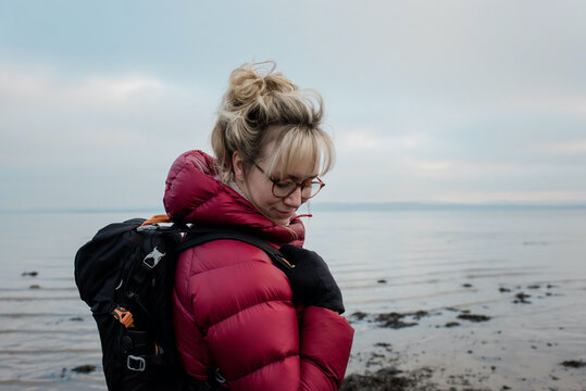 Woman with a backpack hiking alone along the English coast