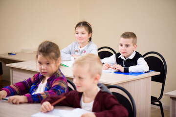 Primary school children work together in class.