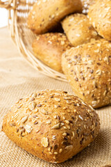 Sliced Multigrain. Rye bakery with crusty loaves and crumbs. Fresh loaf of rustic traditional bread with wheat grain ear or spike plant on natural cotton background. Bio ingredients, very healthy.