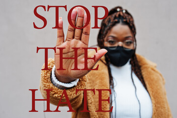 Stop the hate. African american woman, wear black face mask show stop hand sign.