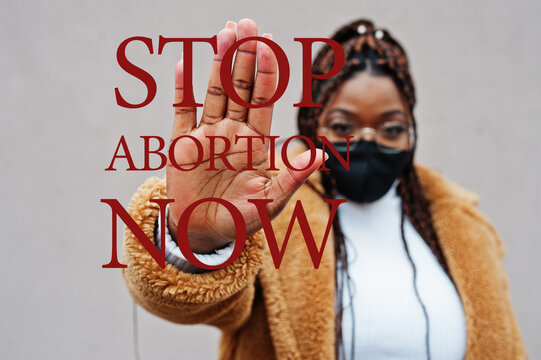 Stop Abortion Now. African American Woman, Wear Black Face Mask Show Stop Hand Sign.