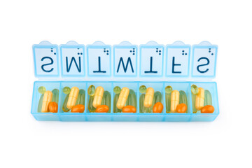 Daily portion of vitamins, drug medicines, tablets, dietary supplements in pill organizer or plactic pill box. A weekly container of tablets, vitamins. Nutritional supplements