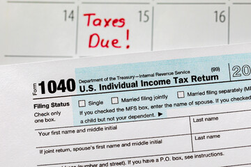 1040 individual income tax return form and calendar with filing deadline date. Concept of filing...