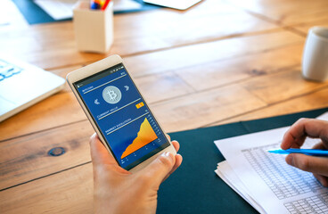 Hand of unrecognizable businessman holding mobile with bitcoins information