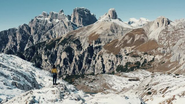 Aerial view over Dolomites mountains in Italian Alps with girl in the middle.