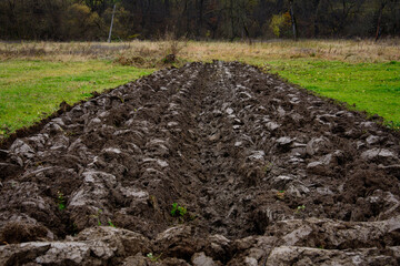 Plowing the land for growing cultivated plants, autumn plowing in the villages. Bed in the area with plowed arable land.