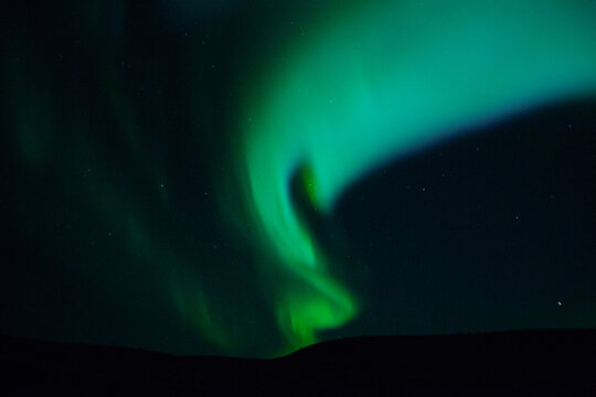 Winter scenic landscape night view of  Aurora Borealis/Northern lights dancing on the clear sky full of stars above lake Myvatn, north Iceland Beautiful winter wonderland/fairytale background scene. 