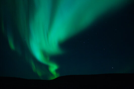 Winter scenic landscape night view of  Aurora Borealis/Northern lights dancing on the clear sky full of stars above lake Myvatn, north Iceland Beautiful winter wonderland/fairytale background scene. 
