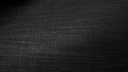 close up dark black sackcloth texture background. rough wavy canvas wallpaper with space for text. natural black color textile burlap background (focused at center).
