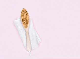  Brush for dry massage on linen towel over pink background. flat lay top view