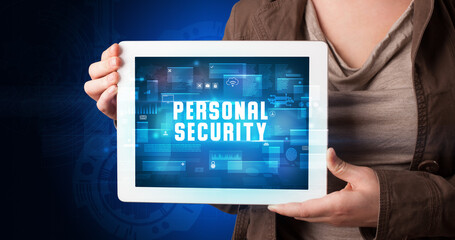 Young business person working on tablet and shows the digital sign: PERSONAL SECURITY