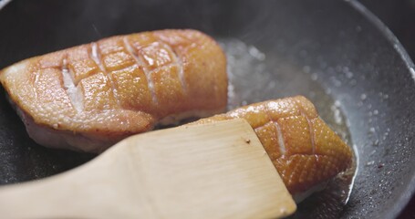 Roast duck breast in frying pen closeup footage