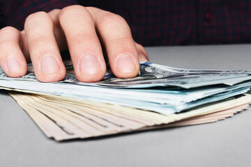 hand and stack of money dollars, giving a bribe close up