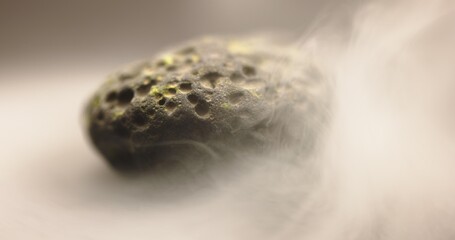 Smoke whirling around small meteorite stone