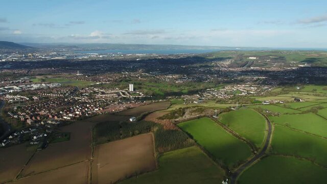Aerial flyover of east Belfast from the countryside looking towards the city centre or center