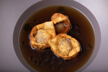 Deep fried crispy and golden dumplings in beef  stock