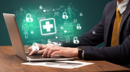 hand browsing on the internet for medical issues with first aid icons coming out from the screen