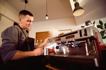 Barista preparing coffee in a coffee shop. Professional coffee making, service and catering concept