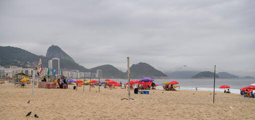 Fototapeta na wymiar Citizens swim and sunbathe on the beach of Copacabana