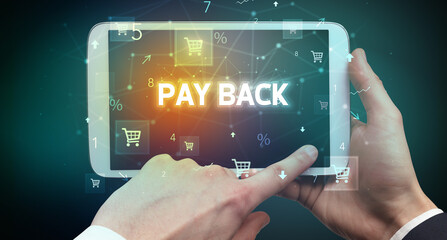 Close-up of a hand holding tablet with PAY BACK inscription, online shopping concept