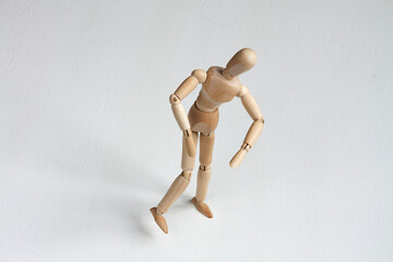a wooden mannequin with bent shoulders on white background