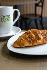 freshly baked chocolate croissant with a cup of tea