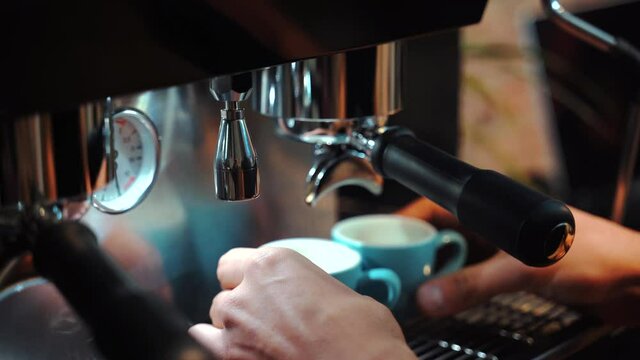 Crop barista using coffee machine in cafe