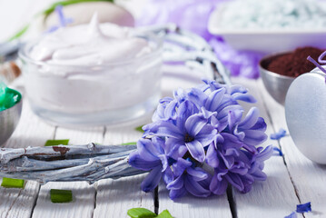cosmetic cream product samples with hyacinth flowers on white wooden background