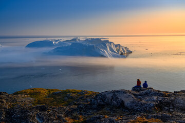 woman in glasses with son sitting on the rocks above the glacial bay © Jaro